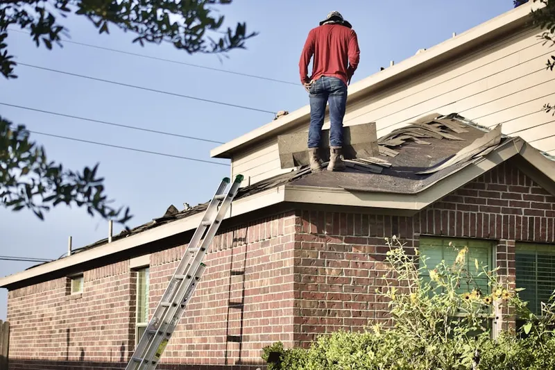 Professional roofer working on a residential roof in Kirkwood